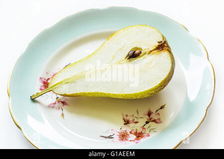 Poire sur une assiette, fond clair Banque D'Images