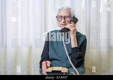 90 ans femme femme en utilisant le téléphone à l'intérieur Banque D'Images