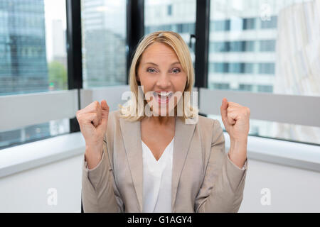 Happy business woman les bras. Arrière-plan de bureau moderne Banque D'Images