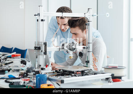 Les jeunes étudiants chercheurs à l'aide d'une imprimante 3D dans le laboratoire, l'ingénierie et de prototypage concept Banque D'Images