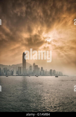 Toits de Central, Hong Kong Island et le port de Victoria avec soleil qui brille derrière les nuages spectaculaires, Hong Kong, Chine, Asie Banque D'Images