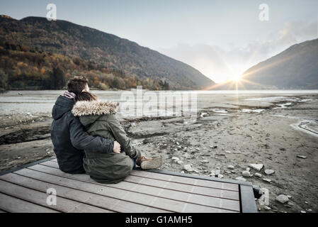 Couple d'amoureux assis sur un quai, accolades et à la voiture, l'amour et les sentiments concept Banque D'Images