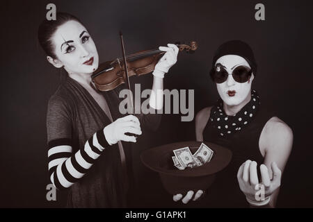 Portrait de deux mimes jouer un violon pour l'argent Banque D'Images