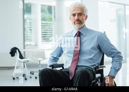 Succès confident businessman in wheelchair smiling at camera, de la carrière et de l'invalidité surmonter concept Banque D'Images