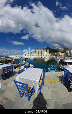 Taverne du Poisson Bleu avec tables chaises donnant sur le château byzantin de Myrina paysage pittoresque. L'île de Lemnos, Grèce Banque D'Images