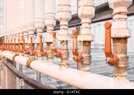 Poignées Orange sur blanc tubes dans une usine Banque D'Images