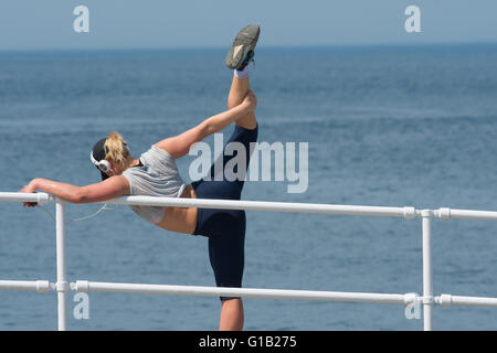 Aberystwyth, Pays de Galles, Royaume-Uni, jeudi 12 mai 2016 UK Weather : Une jeune femme fait ses exercices d'étirement à la station balnéaire d'Aberystwyth, le dernier jour de beau temps dans la mini-canicule. Les températures sont mis à tomber dans les jours à venir, avec des conditions plus froides mais au pays Crédit photo : Keith Morris / Alamy Live News Banque D'Images