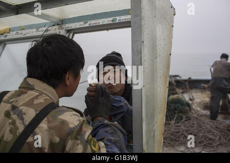 Xingcheng, province de Liaoning, Chine. 9 mai, 2016. Comme les ressources halieutiques côtières de la Chine sont de plus en plus décimées au cours des deux dernières décennies, causé par la pollution et la surpêche, l'augmentation des coûts de la pêche ont changé la vie des pêcheurs chinois évidemment. De nombreux pêcheurs ont choisi de vendre leurs bateaux et complètement renoncer à la vie de la pêche. La mer de Bohai est la source des ressources halieutiques marines dans le Nord de la Chine à l'avant, mais maintenant, la mer est devenue presque vide et de nombreuses espèces ont disparu. Wang Zhiqiang, a près de 40 ans, pêcheur qui vit à Xingcheng city, à Liaoning provinc Banque D'Images