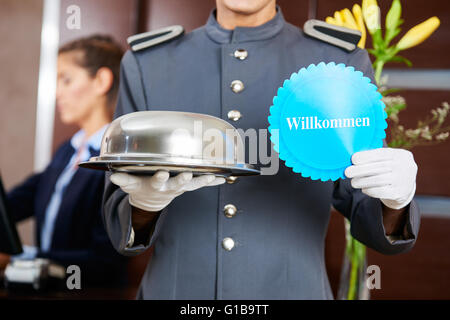 Page de l'hôtel allemand holding panneau disant "Willkommen" (Bienvenue) Banque D'Images