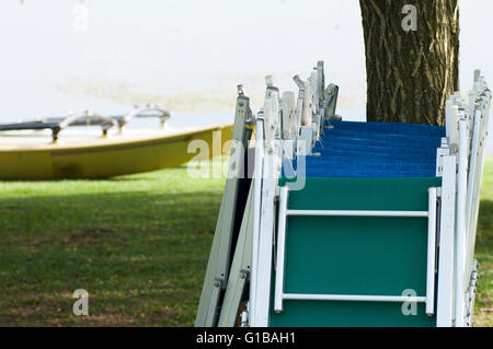 Chaises vides en ligne sur le lac. Banque D'Images