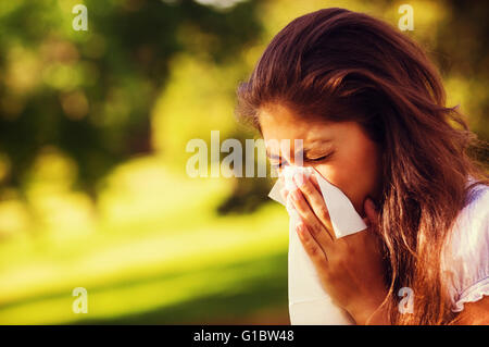 Woman blowing nose avec papier de soie du park Banque D'Images