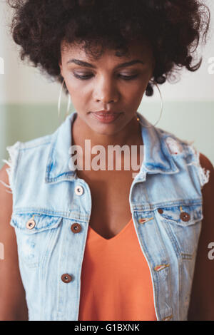 Portrait d'une femme africaine pensif. Jeune modèle féminin élégant à la recherche vers le bas. Banque D'Images