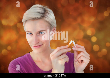 Image composite de jolie blonde breaking cigarette Banque D'Images