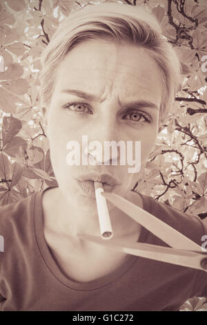 Image composite de belle blonde fine une cigarette Banque D'Images