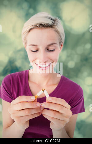 Image composite de jolie blonde breaking cigarette Banque D'Images