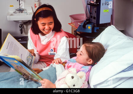 Jeune coréen de compassion et d'encouragement à sortir avec une petite fille très malade avec le cancer. M. ©Pearson Myrleen Banque D'Images