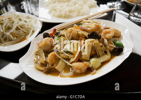 La cuisine chinoise - faire revenir les crevettes avec légumes et champignons. Banque D'Images