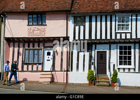 Deux hommes en passant devant les maisons à colombages dans le village de Long Melford, Suffolk, Angleterre, Royaume-Uni Banque D'Images