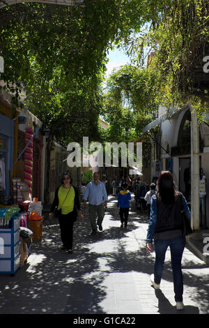 Les gens qui marchent le long de la rue centrale P. Kida de Myrina's city centre, entouré par les entreprises locales. Limnos, Grèce Banque D'Images