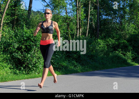 Une blonde woman running barefoot Banque D'Images