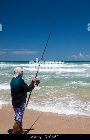 Titusville, Floride - Un pêcheur dans l'Océan Atlantique surf à Canaveral National Seashore. Banque D'Images