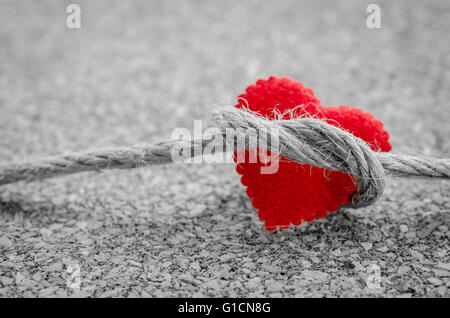 Coeur rouge avec une corde sur un ensemble noir et blanc couleur de bois Banque D'Images