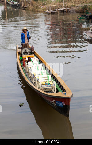 Un bateau de tourisme allant de nouveau vide sur le lac Inle (Myanmar). Ces bateaux pour des excursions tous les sièges ont mis en place dans un seul fichier. Banque D'Images