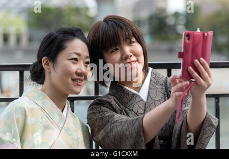 Deux japonaises habillées en kimono traditionnel selfies prendre une avec téléphone mobile, Tokyo Banque D'Images