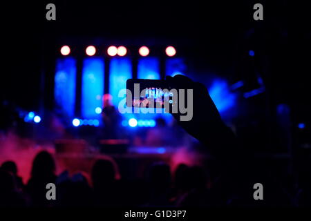 Une personne prenant des photos d'un concert de rock avec un smartphone dans la ville d'Eilat, Israël Banque D'Images