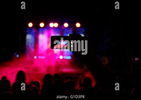 Une personne prenant des photos d'un concert de rock avec un smartphone dans la ville d'Eilat, Israël Banque D'Images