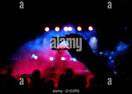 Une personne prenant des photos d'un concert de rock avec un smartphone dans la ville d'Eilat, Israël Banque D'Images