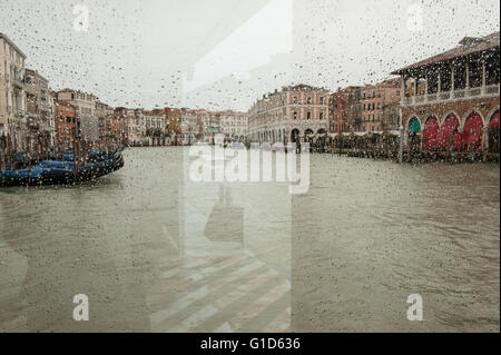 Venise sous la pluie, à travers le verre à un arrêt de vaporetto Banque D'Images