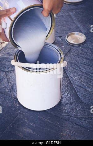 Les mains d'un homme versant peinture, soft focus sélectif, tonification Banque D'Images