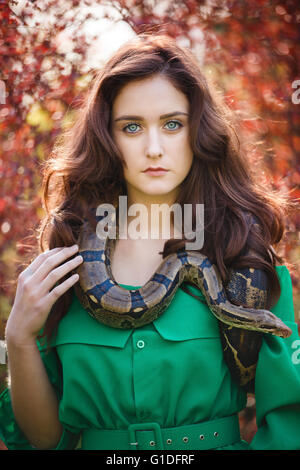 Portrait de la belle adolescente avec snake dans un jardin Banque D'Images