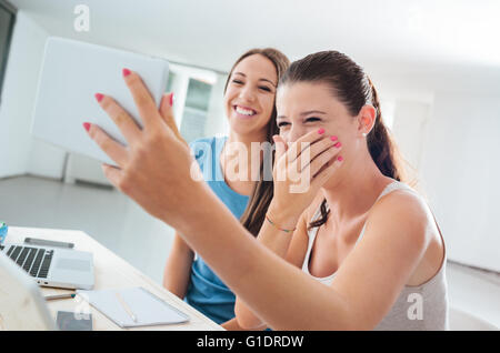 Heureux les adolescents à la maison à vos autoportraits avec un écran tactile Tablet et d'avoir du plaisir Banque D'Images