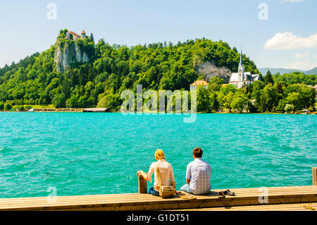 Couple sur le bord de mer à l'autre côté du lac Blejsko Jezero (Bled, Slovénie), à la Cathédrale et château de Bled Banque D'Images