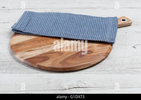 Serviette bleu sur planche à découper ronde blanche sur table en bois rustique. Horizontal image with copy space Banque D'Images