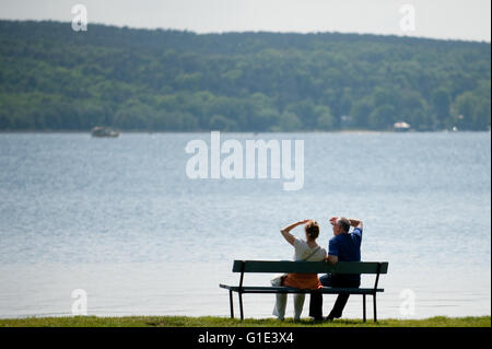 Petzow, Allemagne. 13 mai, 2016. Deux personnes sont assises sur un banc à la zone de baignade du lac Schwielowsee de Petzow, Allemagne, 13 mai 2016. La qualité de l'eau de tous les 251 lacs de baignade est excellente selon le ministère de l'consommateurs de Brandebourg. Photo : Klaus-Dietmar Gabbert/dpa/Alamy Live News Banque D'Images