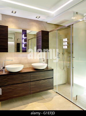 Maison Blanche, L'Ametlla. Salle de bains moderne avec cabine de douche, double vasque, et des armoires en bois. Banque D'Images