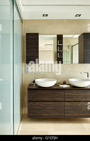 Maison Blanche, L'Ametlla. Salle de bains moderne avec cabine de douche, double vasque, et des armoires en bois. Banque D'Images