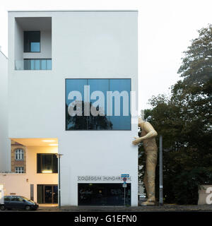 Le Collegium Hungaricum à Berlin, Allemagne. L'extérieur de l'édifice avec une grande statue d'un homme appuyé contre le mur de côté. Signe sur l'avant du bâtiment l'entrée. Banque D'Images