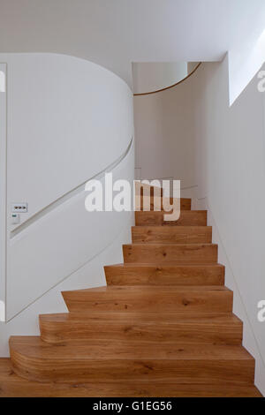 Maison familiale moderne, Shepherds Bush, Londres. Escalier en bois en spirale et des murs blancs. Banque D'Images