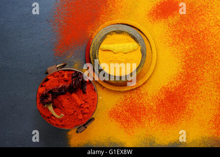 Ensemble d'épices le poivre et le curcuma, en métal vintage tasses sur jaune poudre de curcuma. Vue d'en haut. Concept de cuisine épicée ou des aliments, Banque D'Images