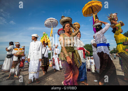 Les hommes et les femmes de la foi hindoue balinaise qui participent à une procession à la cérémonie religieuse Melasti sur l'île de Bali Banque D'Images