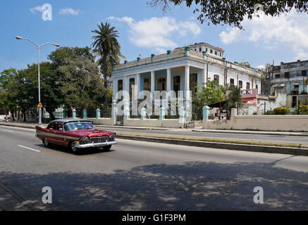 Une voiture américaine classique passe par un hôtel particulier dans le Vedado, La Havane, Cuba Banque D'Images