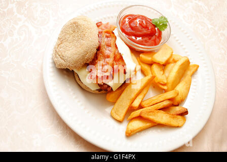 Bacon Cheeseburger servi sur un muffin anglais de blé avec des pommes de terre sautées Banque D'Images