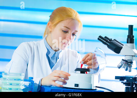 Parution du modèle. Female Lab technician holding échantillon dans le laboratoire. Banque D'Images