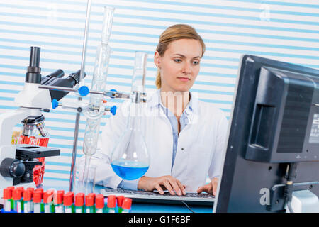 Parution du modèle. Chimiste femelle à l'aide d'ordinateur dans le laboratoire. Banque D'Images