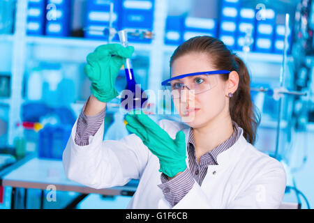 Parution du modèle. Chimiste femelle holding in laboratory. Banque D'Images