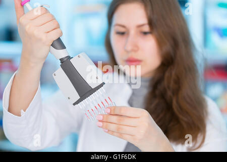 Parution du modèle. Female scientist en utilisant une pipette multi. Banque D'Images